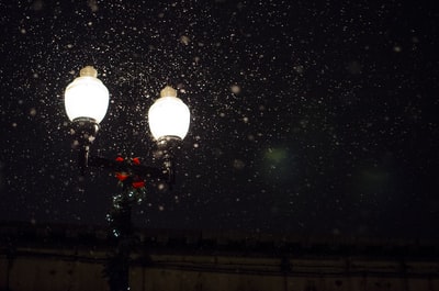 角度的照片2-bulb灯与雪落在夜间
